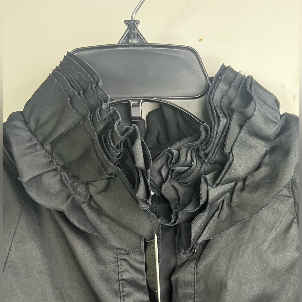 Unique and stylish black ruffle collar shirt.